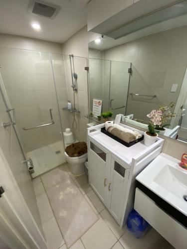 a bathroom with a toilet and a shower and a sink at Crissome Suite Azure North San Fernando Pampanga in Lagundi