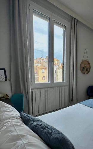 a bedroom with a bed and a large window at Negrecoste Hôtel & Spa in Aix-en-Provence