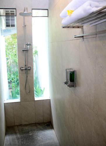 a shower stall in a bathroom with a window at Delu Villas & Suite in Kerobokan