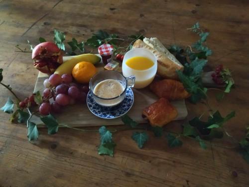 une table avec une assiette de nourriture et une tasse de café dans l'établissement Ecurie Le Pas du Loup, à Caumont-sur-Durance