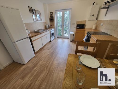 a kitchen with a table and a kitchen with a refrigerator at FREE Parking - Waterfront - Relocators - ST in Hull