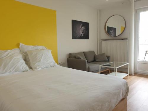 une chambre avec un grand lit blanc et un canapé dans l'établissement Le Nid de Metz, à Metz