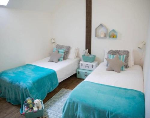 two beds in a room with blue and white at Les Bergeronnettes in Camors