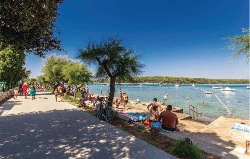 a group of people on a beach near the water at Cozy Home In Punat With Sauna in Punat