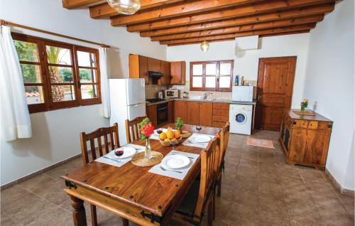 a kitchen with a wooden table with chairs and a dining room at Stunning Home In Pomos With Wifi in Pomos