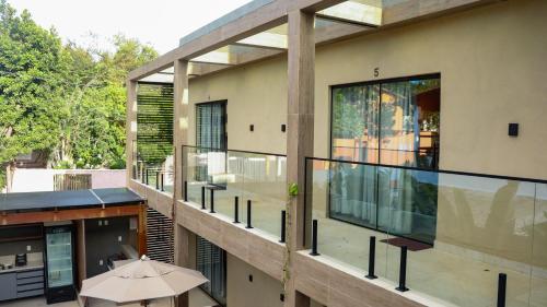a house with an open balcony with an umbrella at Pipa Day Flats in Pipa
