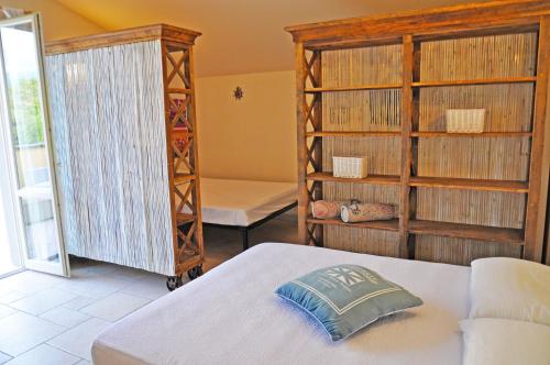 pokój z łóżkiem i pokój z półkami w obiekcie Holiday Apartments Fiumetto w mieście Marina di Pietrasanta