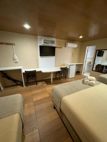 a room with two beds and a table and chairs at Pousada da Germana in Fernando de Noronha