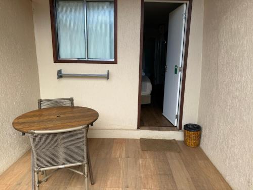 a table and two chairs in a room with a door at Pousada da Germana in Fernando de Noronha