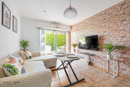 un salon avec un mur de briques dans l'établissement Havre de paix à Villeneuve Loubet, à Villeneuve-Loubet