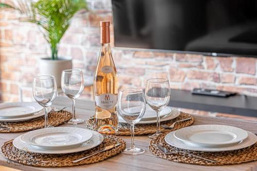 - une table avec des verres et une bouteille de vin dans l'établissement Havre de paix à Villeneuve Loubet, à Villeneuve-Loubet