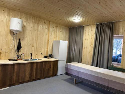a kitchen with a refrigerator and a sink and a window at Arde in Mestia