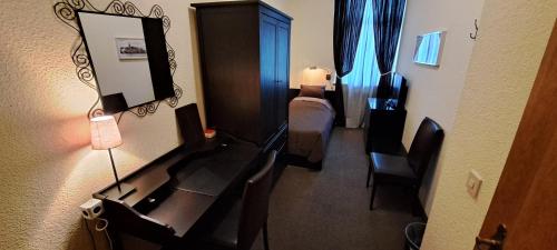 a room with a desk with a mirror and a bed at Parkhotel Essen in Essen