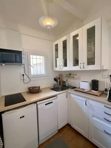 une cuisine avec des armoires blanches et un évier dans l'établissement Terrasse à Aix en Provence centre historique, à Aix-en-Provence