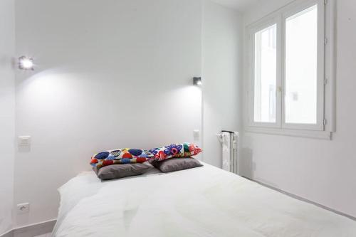 un lit blanc avec deux oreillers dessus dans l'établissement MARSEILLE superbe appartement à 2m de la plage, à Marseille
