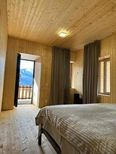 a bedroom with a bed and a large window at Arde in Mestia