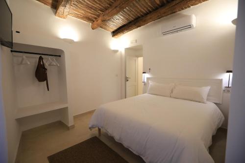 - une chambre blanche avec un lit blanc et un mur blanc dans l'établissement Ai 13 Gradoni di Chiaia, à Naples