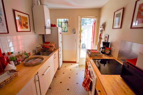 une cuisine avec un évier et un réfrigérateur dans l'établissement La Maison des Pins Arcachon Les Abatilles, à Arcachon