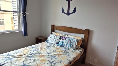 Schlafzimmer mit einem Bett mit Anker an der Wand in der Unterkunft Verdadeiro Pé na Areia in Santos