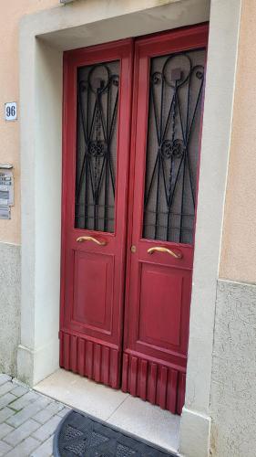 a red door with two windows on a building at Lovely Escape in Venice in Mestre