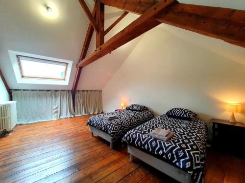 a bedroom with two beds and a window and wooden floors at La Capitainerie Port du Légué in Plérin