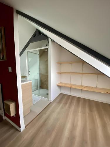 Cette chambre mansardée dispose d'étagères et d'un placard. dans l'établissement Maison familiale avec extérieur Ménage et linges inclus, à Rouen