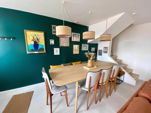 une salle à manger avec des murs verts, une table et des chaises dans l'établissement Maison familiale avec extérieur Ménage et linges inclus, à Rouen