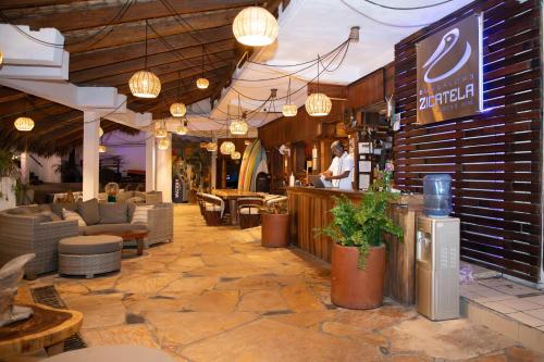 a man standing at a bar in a restaurant at Bungalows Zicatela in Puerto Escondido