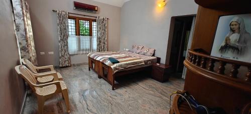 a bedroom with a bed and a portrait of a man at Alite Posh 4 BHK Villa in Thrissur Town in Trichūr