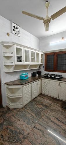 a kitchen with white cabinets and a ceiling at Alite Posh 4 BHK Villa in Thrissur Town in Trichūr