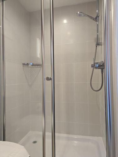 a bathroom with a shower with a glass door at Cartref Guesthouse - Room 2 Ensuite in Aberdyfi