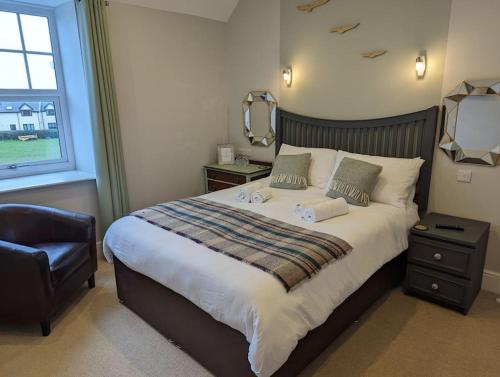 a bedroom with a large bed with a mirror and a chair at Cartref Guesthouse - Room 2 Ensuite in Aberdyfi