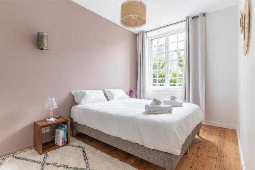 Un dormitorio blanco con una cama y una ventana. en Appartement Central et Calme avec Magnifique Vue, en Nantes