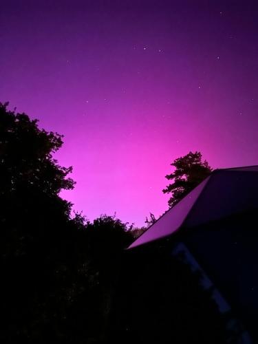 a purple and purple sky with trees and a house at Demeure de la Garenne in Montmirail