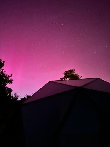 a purple and pink sky with a building and trees at Demeure de la Garenne in Montmirail
