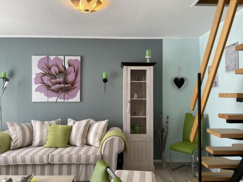 a living room with a couch and a green chair at Ferienhaus DolceVita in Walkenried