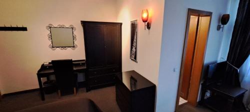 a living room with a desk and a mirror at Parkhotel Essen in Essen