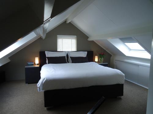 a bedroom with a large bed in a attic at Aan de Amstel in De Hoef