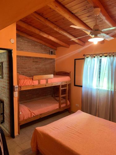 a bedroom with two bunk beds and a ceiling fan at INTI MAYU Cabañas in Mina Clavero