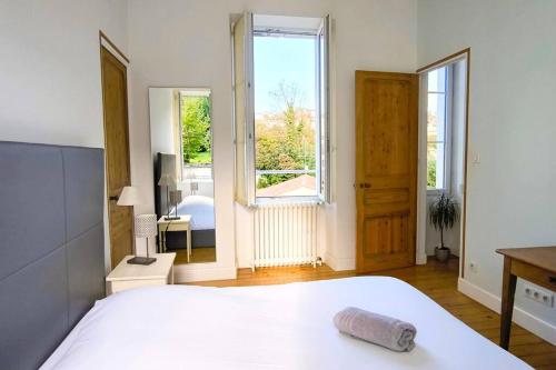 a bedroom with a large white bed and a window at Maison 6pers-Centre ville-Jardin in Angoulême