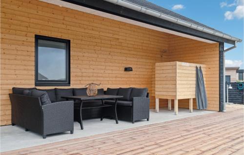 a patio with couches and a table on a deck at Nice Home In Thisted With Sauna in Thisted