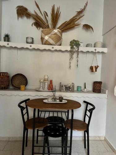 a table and chairs in a kitchen with shelves at DownTown Apartment Konitsa in Konitsa