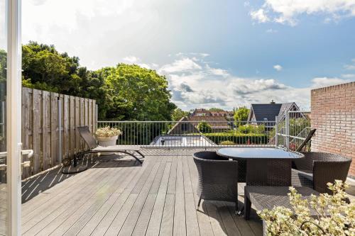 a patio with a table and chairs on a deck at De Lijsterhof in Domburg
