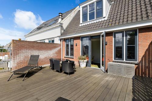 a deck with chairs and a table on a house at De Lijsterhof in Domburg