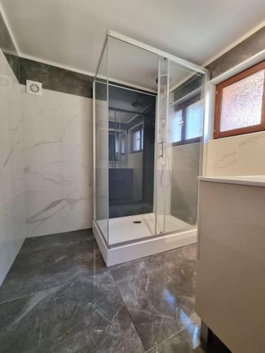 La salle de bains est pourvue d'une douche et d'une cabine de verre. dans l'établissement Le Hameau Frontalier, à Buschwiller