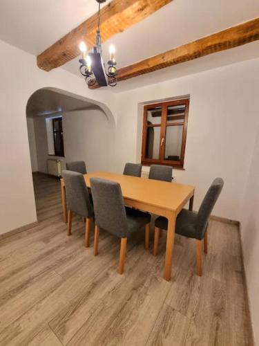 une salle à manger avec une table et des chaises en bois dans l'établissement Le Hameau Frontalier, à Buschwiller