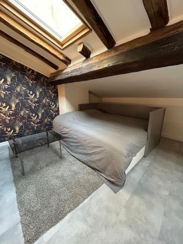 une chambre avec un lit dans une pièce avec une fenêtre dans l'établissement Le cozy, Jean Jaurès, à Toulouse
