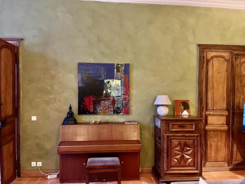 a room with a piano and a painting on the wall at Chambres d'hôtes au Château de Gandillac in Saint-Martial-Viveyrol