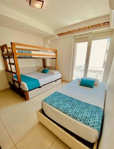 a bedroom with two bunk beds and a window at Depto Excelente ubicación Vista parcial Mar in Boca del Río