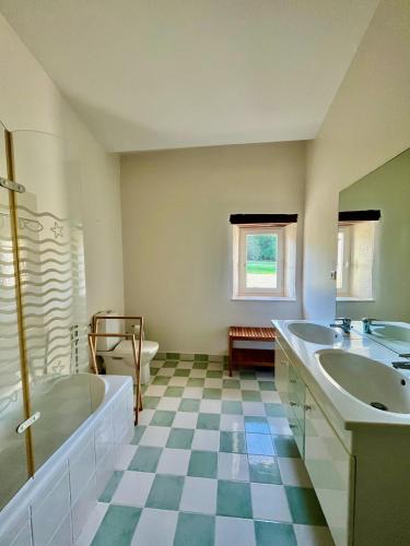 a large bathroom with two sinks and a tub and a tub at Chambres d'hôtes au Château de Gandillac in Saint-Martial-Viveyrol